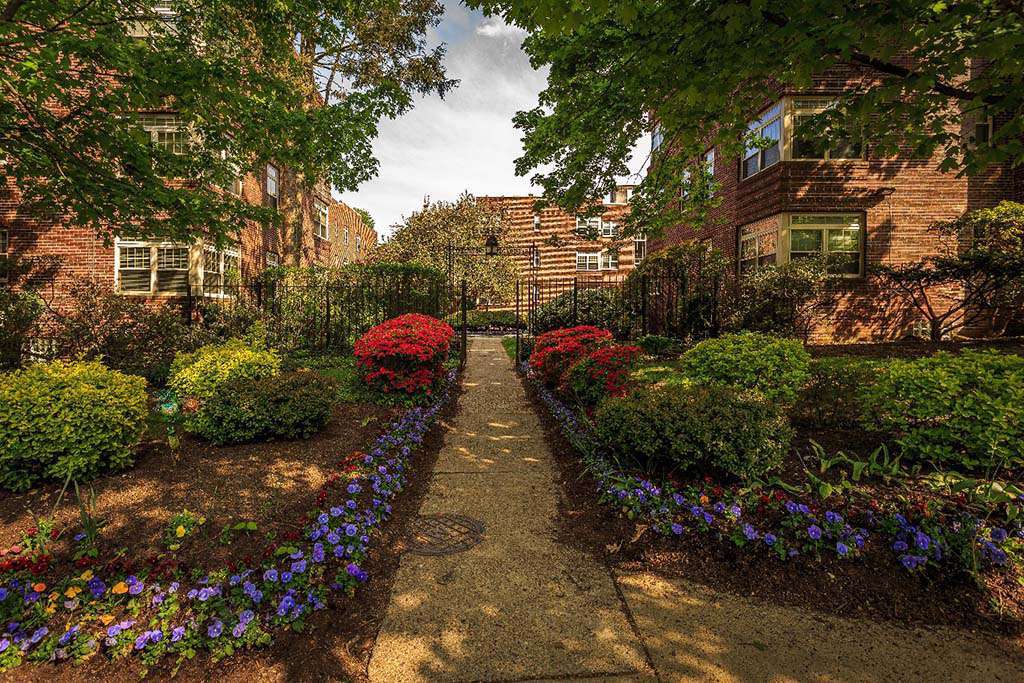 Beautifully landscaped entrance surrounded by flowers at Sedgwick Gardens apartments for rent