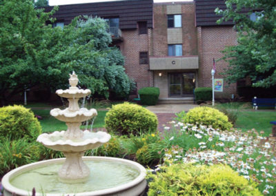 Garden with a fountain and flowers at Fountain Gardens apartments for rent in Philadelphia, PA