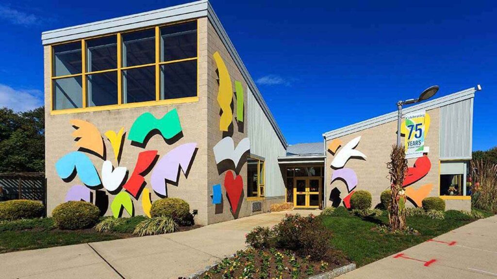Exterior view of the colorful building entrance at The Enclaves at Packer Park apartments for rent in Philadelphia, PA