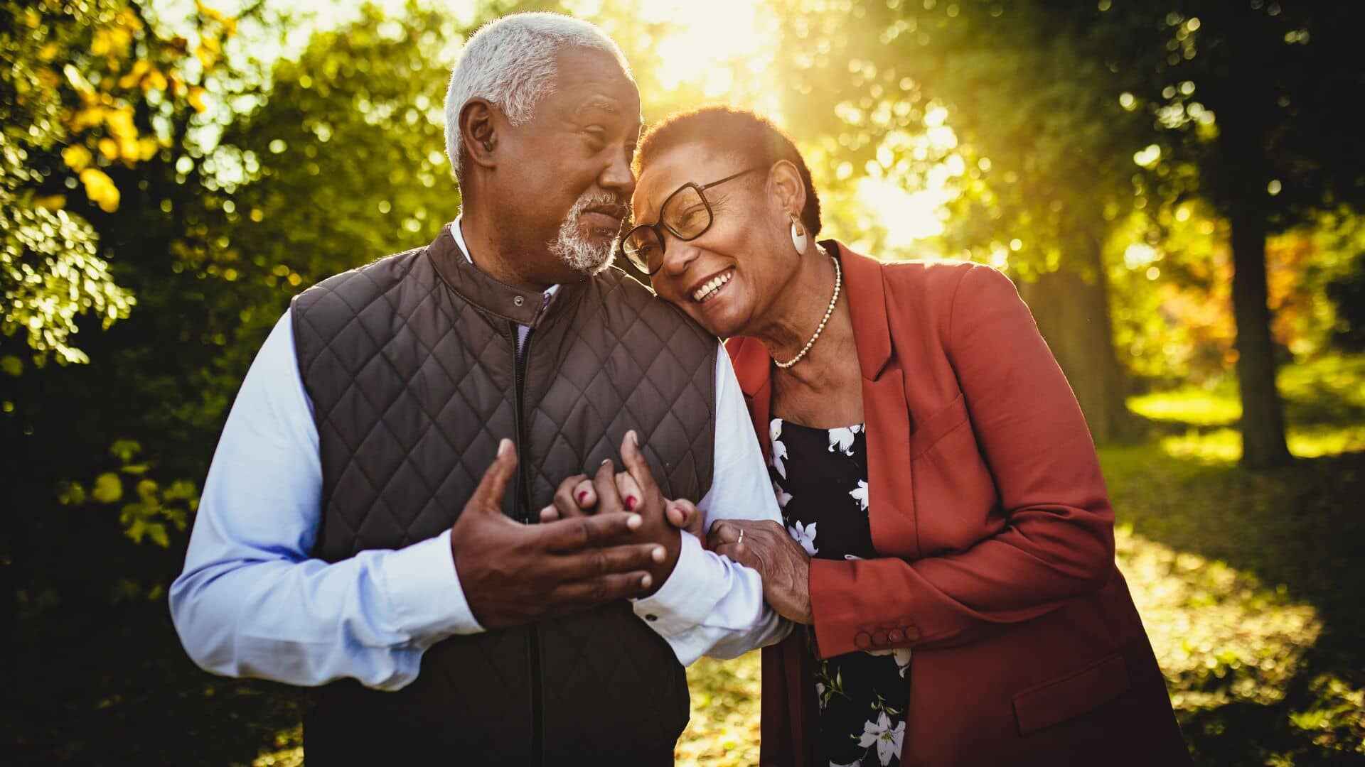 Senior couple walking arm in arm through a park