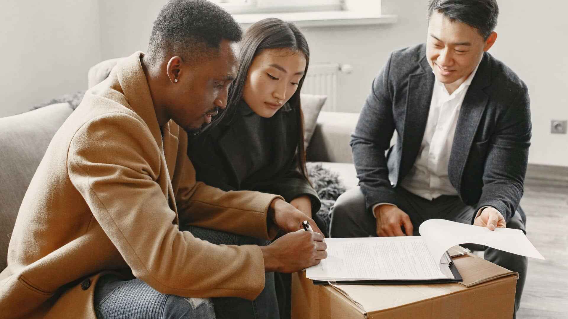 A couple signing a leasing agreement with a leasing specialist
