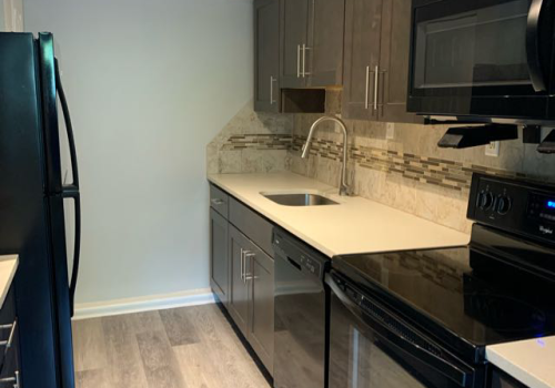 Kitchen with dark cabinets and white quartz countertop