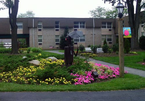 Garden with pink and yellow flowers outside of 450 Green apartments for rent in Norristown, PA