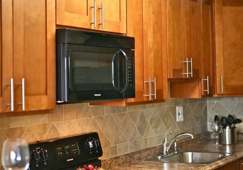 Kitchen with an oven, sink, and wine glass at Chelboune Plaza apartments for rent