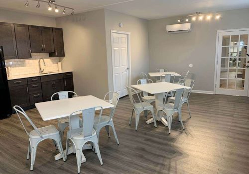 A community kitchen at Crossings at Stanbridge apartments for rent with two tables and chairs