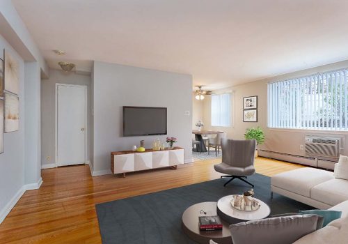 Living room with a couch, chair, and TV at Eola Park apartments for rent in Philadelphia, PA