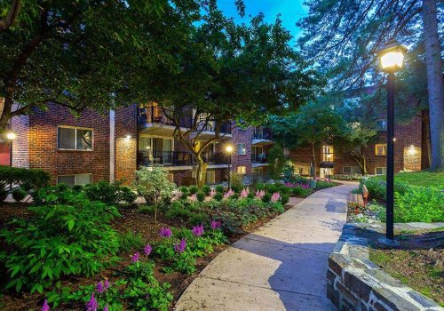 Beautifully landscaped entrance walkway to residential buildings at Haverford Court apartments