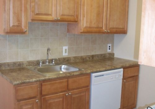 Kitchen with brown cabinetry at Longwood Manor apartments for rent