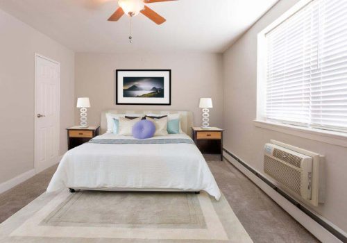 Fully furnished bedroom with a ceiling fan and large window at Mt Airy Place in Philadelphia, PA