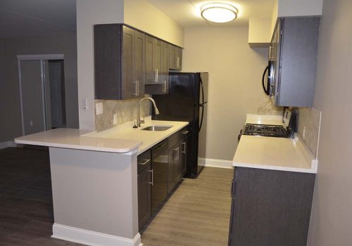 Kitchen with a refrigerator, sink, and stovetop at The Gateway Towers at Packer Park apartments for rent