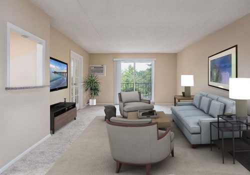 Tan living room with balcony, grey couch, beige chairs, and TV at Park at Westminster apartments.