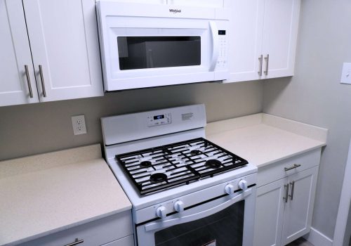 White modern kitchen with modern appliances and quartz countertop