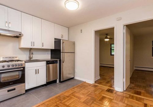 2-bedroom unit with updated kitchen with white cabinets and open concept living and dining room.